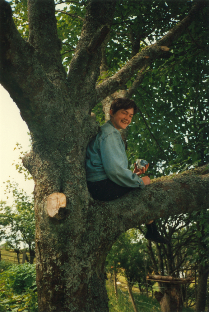 a photograph of my sister sitting in a tree drinking tea